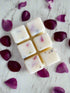 Damson & Rose Botanical Wax Melt Bar showcasing creamy wax cubes with floral accents on a vibrant floral backdrop.