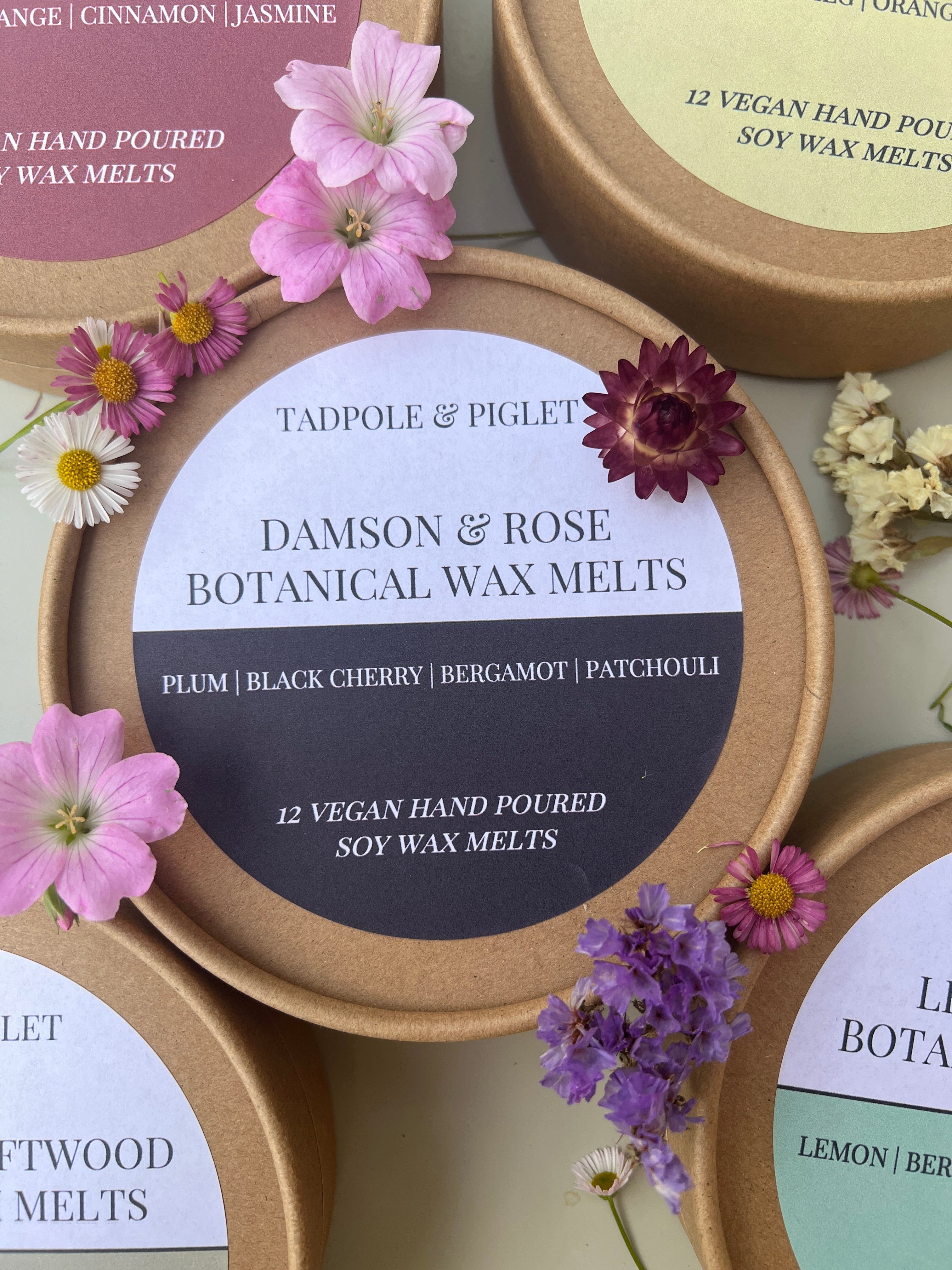 Damson &amp; Rose Botanical Wax Melts tin with flowers, featuring scents of plum, black cherry, and bergamot.